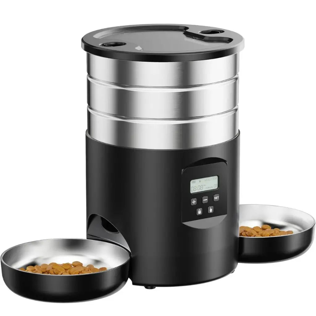 Black and silver pet food dispenser with two bowls of food on a white background