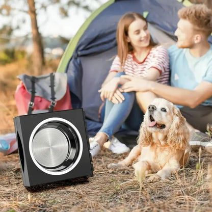 Black raised dog bowl on a camping ground with a couple and a dog in the background
