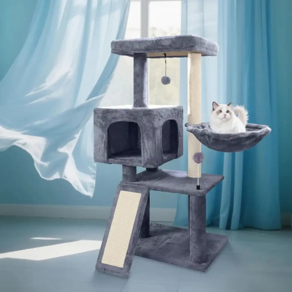 Cat tree with a cat perched on it against a blue curtain background