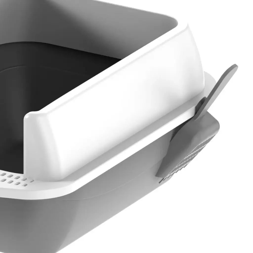 Gray and white pet litter box with a scoop on a white background