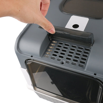 Hand opening a gray cat litter box with a transparent door