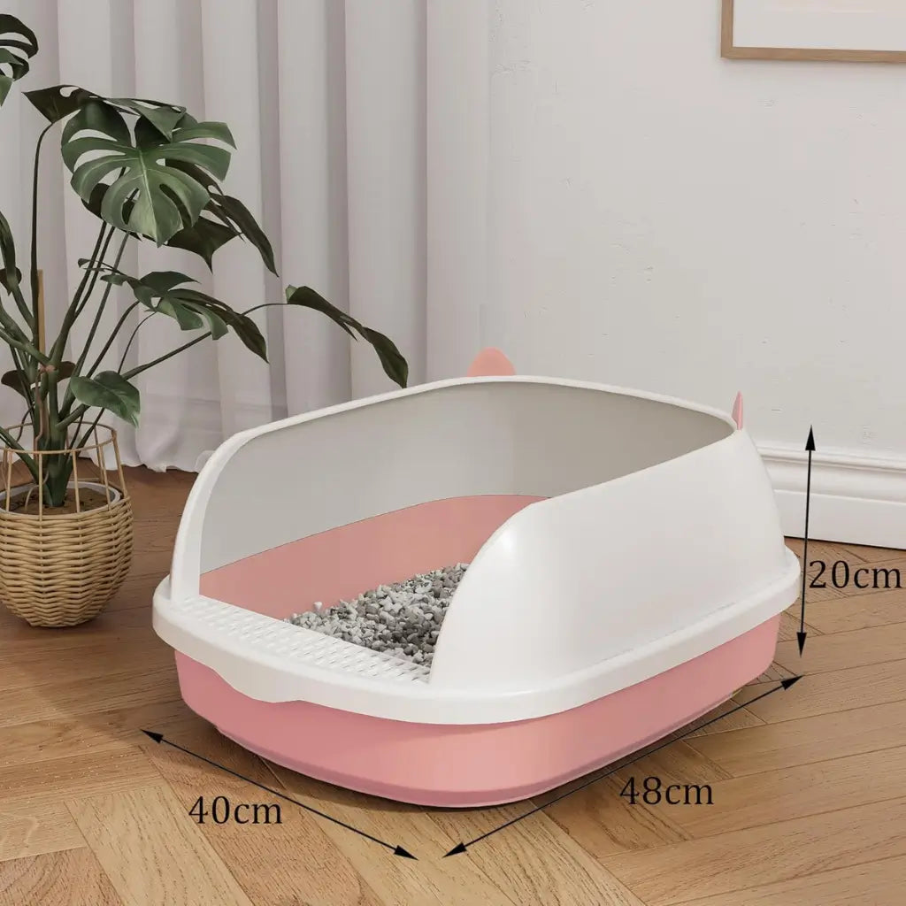L Pink and white pet litter box with dimensions on a wooden floor