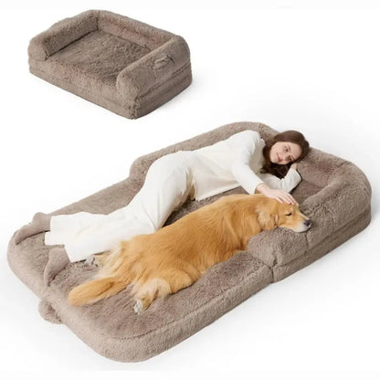 Large fluffy pet bed with a person and dog lying on it against a white background