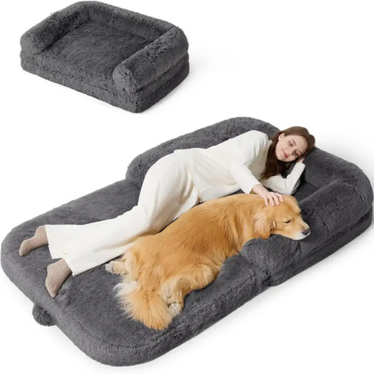 Large gray pet bed with a person and dog lying on it, showing the comfort and size of the product