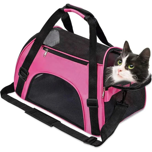 Pink and black pet carrier with a cat peeking out on a white background
