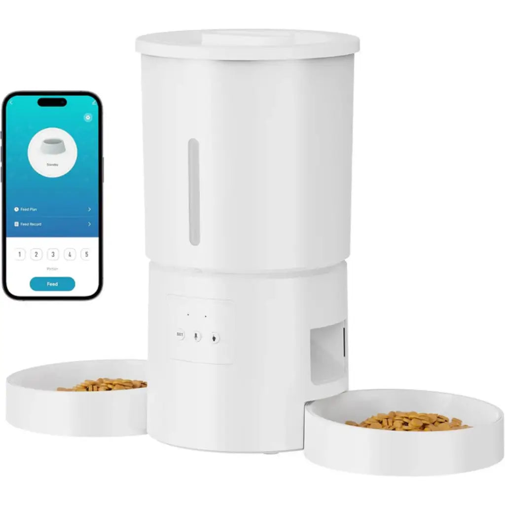 White pet food dispenser with two bowls and a smartphone displaying an app interface